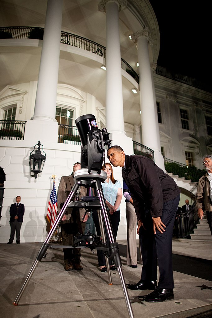 Barack Obama regarde à travers une lunette celestron (PD)