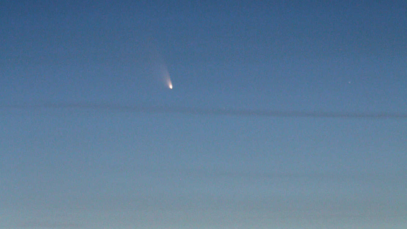 Komet C/2011 L4 (PanSTARRS)
in der Abenddämmerung über dem
Schwarzwald. Das Einzelbild entstand
am 15.3.2013 kurz nach Sonnenuntergang
mit einem Teleobjektiv bei 300mm Brennweite
an einer DSLR vom Typ Canon 550D. U. Dittler