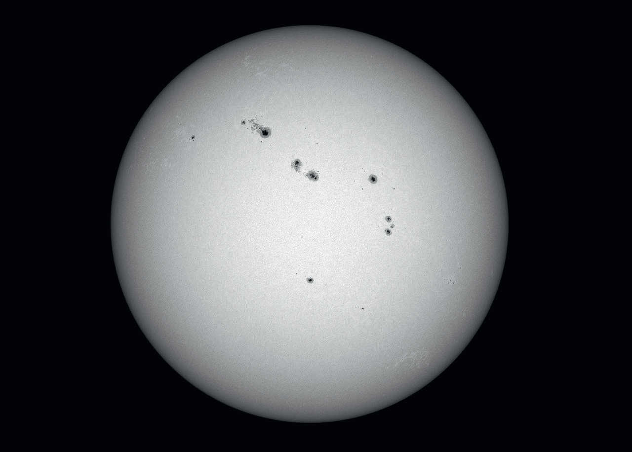 Mit kurzbrennweitigen Optiken (etwa 500 - 600mm Brennweite) können Übersichtsaufnahmen
der Sonnenscheibe gewonnen werden, die die Anordnung der Flecken zeigen. Dieses Bild
wurde mit einer ungekühlten CCD-Kamera an einem Teleskop mit 60mm Öffnung und 600mm Brennweite
aufgenommen (Summenbild aus 500 Bildern aus einer Aufnahmesequenz mit 2500 Bildern). U. Dittler